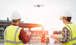Drone land surveying with surveyors operating a drone on a construction site under FAA BVLOS rules
