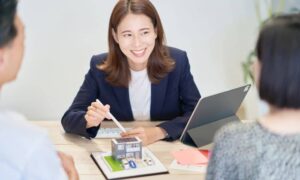 Homebuyers reviewing a boundary survey copy with an agent at the closing table