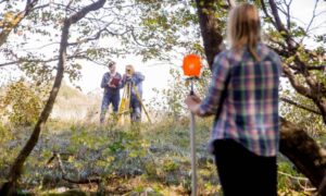 Flawless construction staking survey under tree cover 1 - ALTA SURVEY Mississippi Surveyors performing a construction staking survey under tree cover using total station and prism equipment