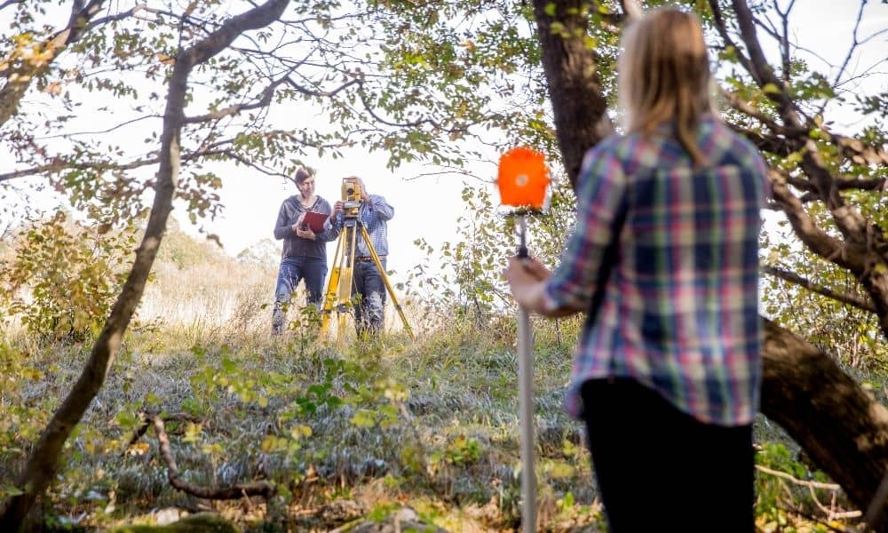 Flawless construction staking survey under tree cover 1 - ALTA SURVEY Mississippi Surveyors performing a construction staking survey under tree cover using total station and prism equipment