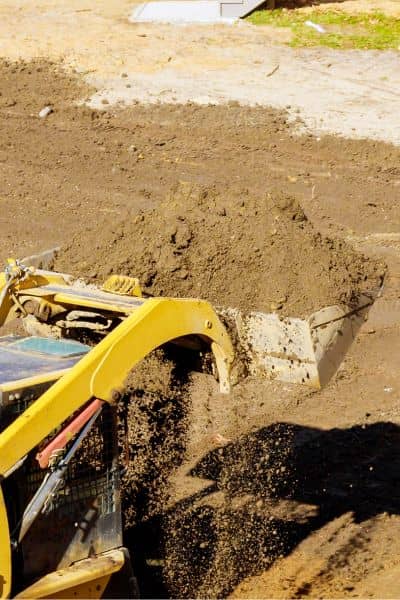 Land grading and soil preparation near a home showing site conditions before ordering an elevation certificate