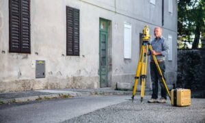 Surveyor using a total station during a construction survey on a city street