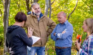 Homeowners reviewing a property line survey with a contractor before starting a fence project