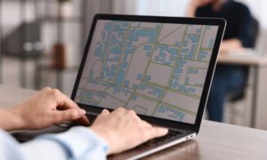 Digital survey workflow laptop - ALTA SURVEY Mississippi Surveyor using a laptop to review a digital map, illustrating how technology can speed up the ALTA Land Title Survey process