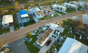 Aerial view of severe storm damage across a neighborhood, captured during drone surveying to help document roof loss and debris