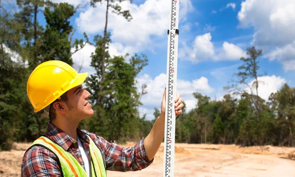 Construction site measurement planning - ALTA SURVEY Mississippi A land surveyor measuring site conditions during early project planning