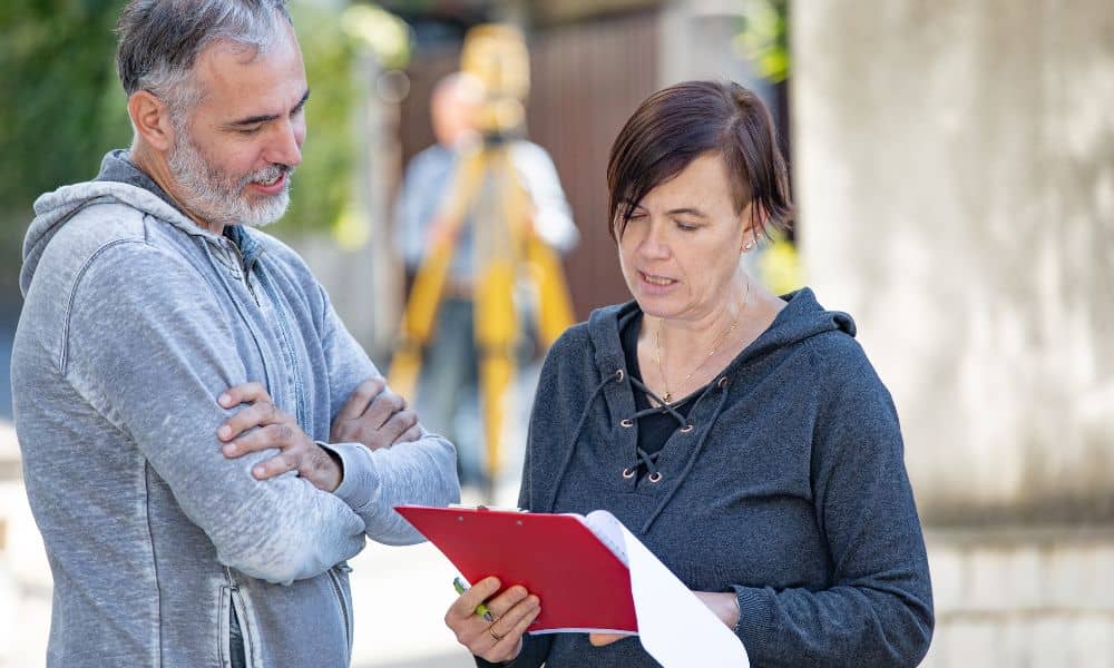 Buyer reviewing a property boundary map during a due diligence survey before closing