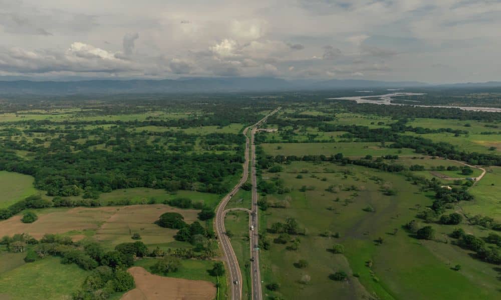 Aerial view of a rural road corridor with open fields and wooded areas, showing the landscape considered in survey mapping